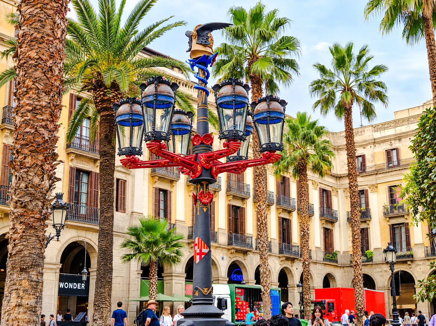 Plaça Reial in Barcelona with ornate street lamp and palm trees.