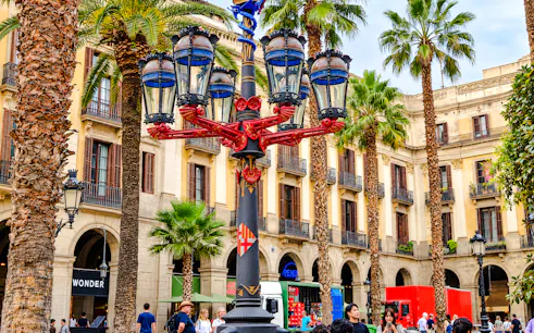 Plaça Reial in Barcelona with ornate street lamp and palm trees.