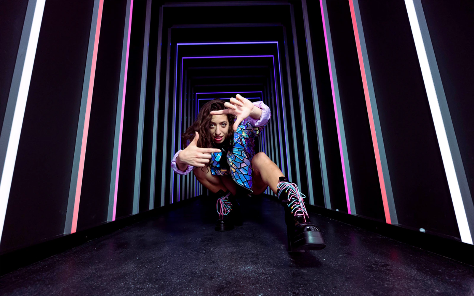 Person posing in a neon-lit tunnel at The Upside Down Berlin.