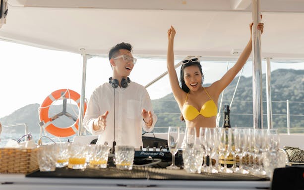 Tourist dancing with DJ on catamaran during Buzios Full Day Tour.