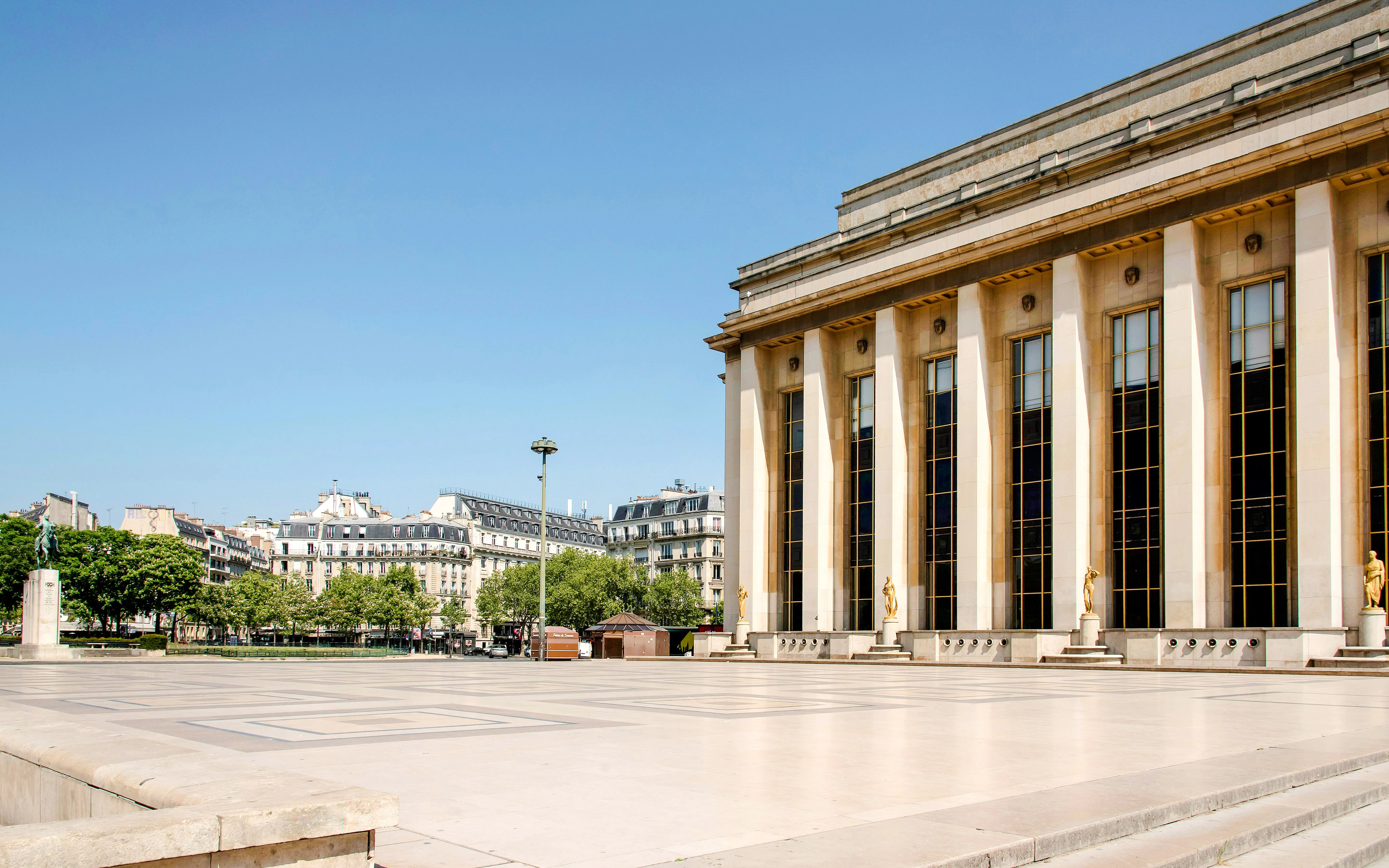 Trocadéro plaza with Palais de Chaillot in Paris, featuring statues and cityscape.