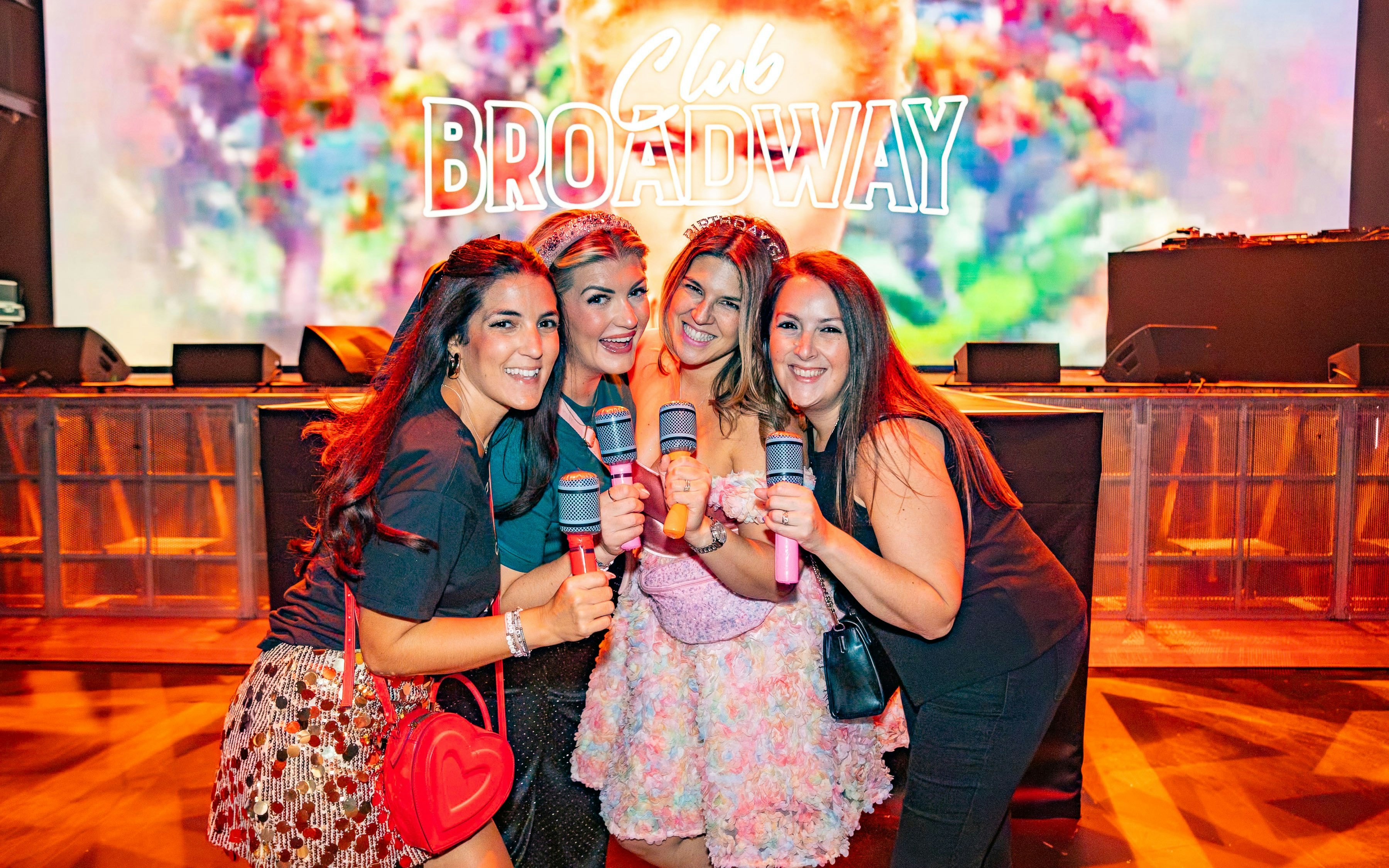 Women holding microphones at Club Broadway, West End event.
