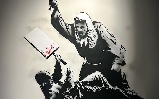 Judge with cleaver in Banksy artwork, featuring red paint splatter.