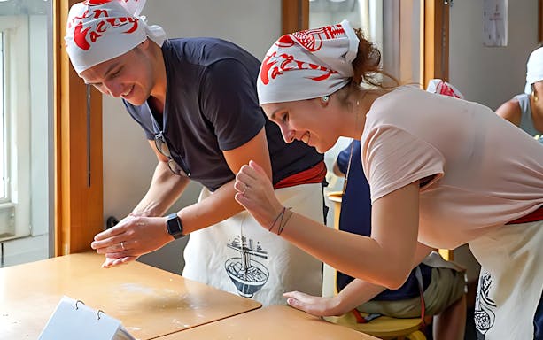 Participants making ramen at a cooking class in Kyoto's Ramen Factory.