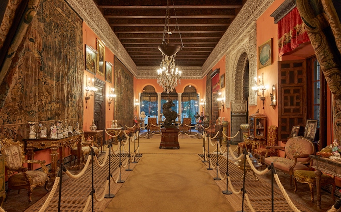 Palacio de las Dueñas interior with ornate decor and chandeliers, Seville.