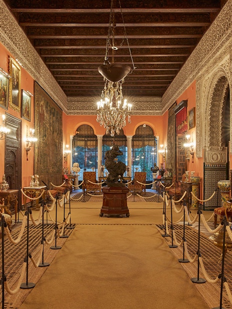 Palacio de las Dueñas interior with ornate decor and chandeliers, Seville.