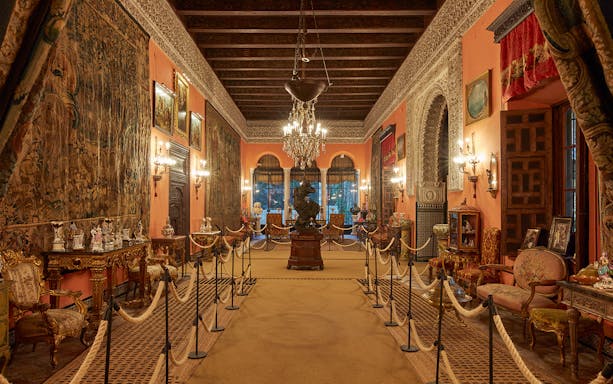 Palacio de las Dueñas interior with ornate decor and chandeliers, Seville.