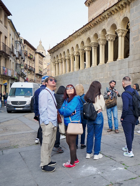 Visitors with a guide exploring historic architecture in Segovia.
