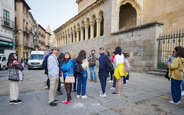Visitors with a guide exploring historic architecture in Segovia.