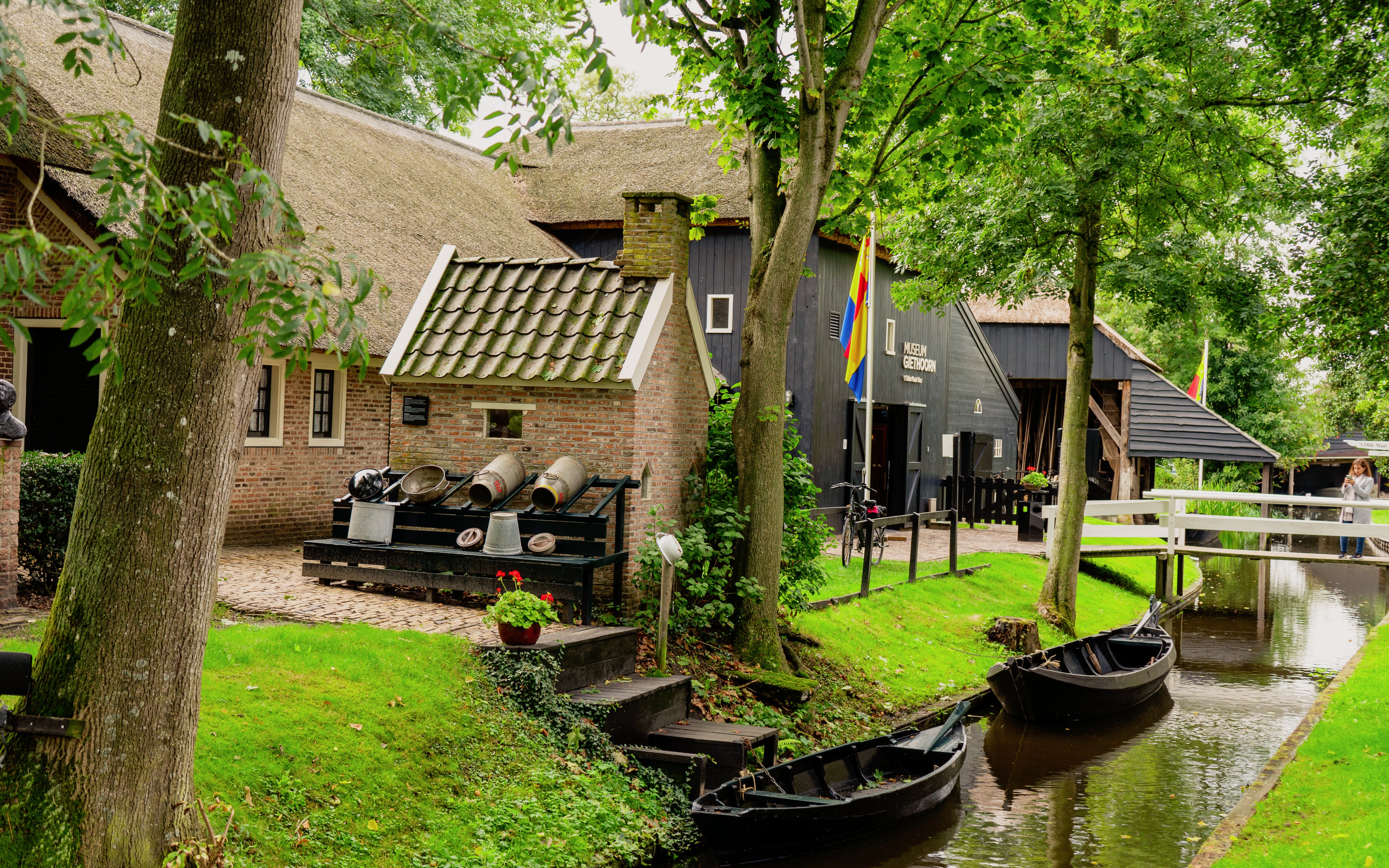 Museum in Giethoorn village center with canal and boats, Netherlands.
