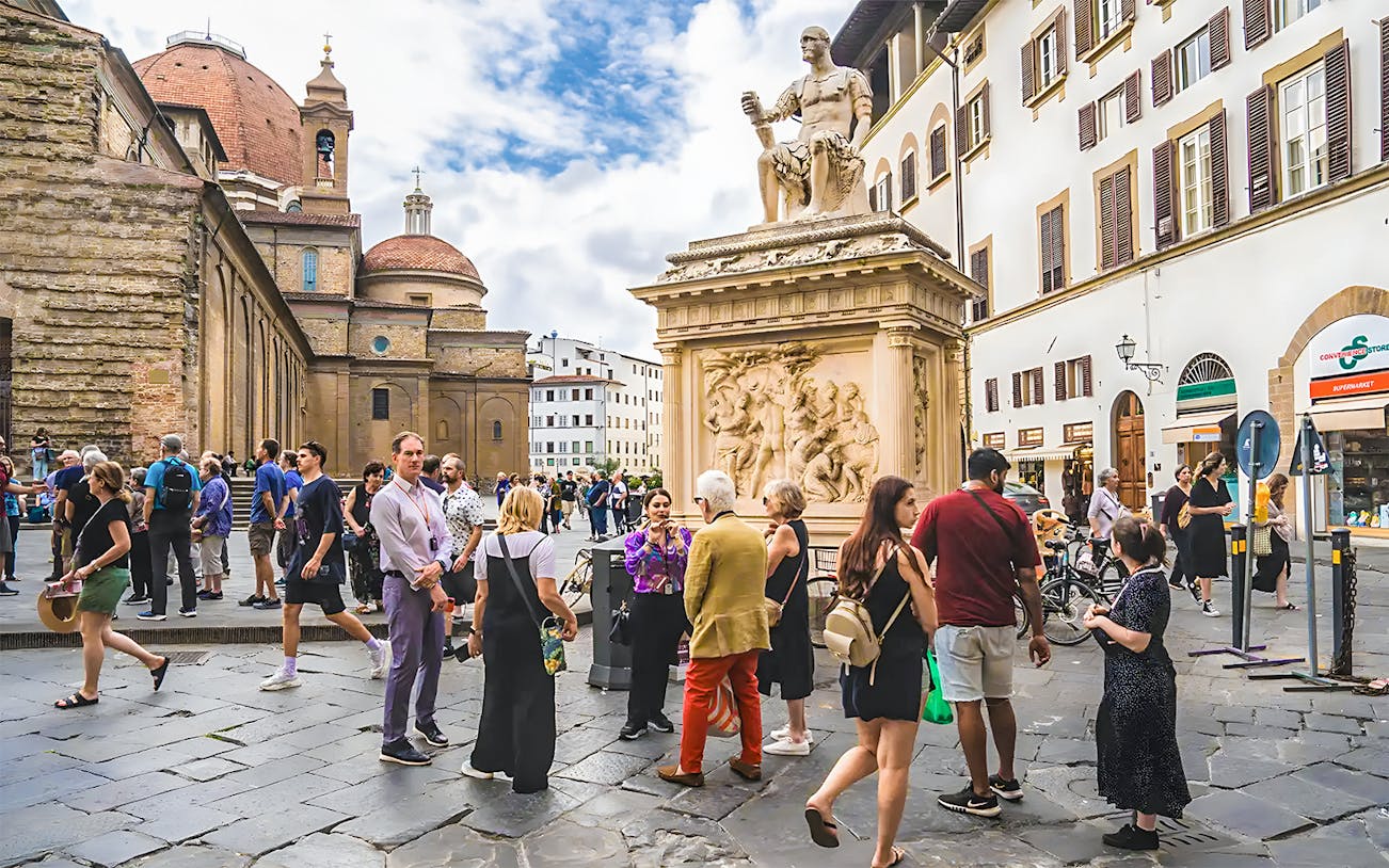 Tourists gather near a statue on Medici's Mile in Florence, Italy.