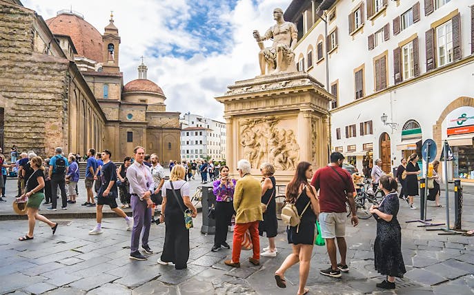 Tourists gather near a statue on Medici's Mile in Florence, Italy.
