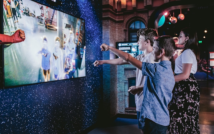 Visitors interacting with a superhero exhibit at Madame Tussauds Sydney.