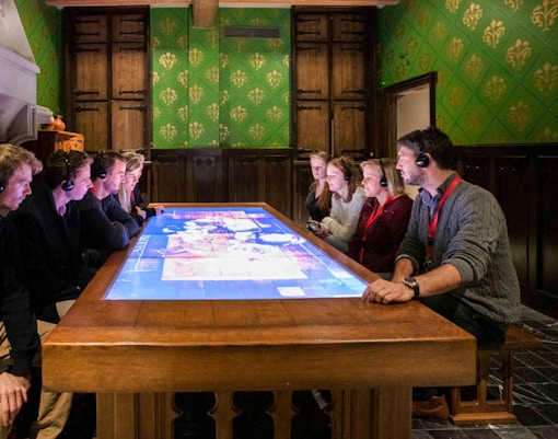 A group of people seated and witnessing the first stock exchange through a virtual reality setting.