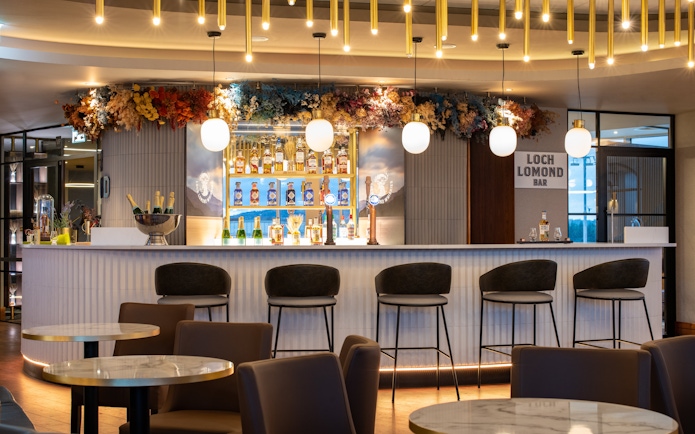 Bar area in Turkish Airlines Lounge by Plaza Premium Group at Edinburgh Airport, featuring seating and drinks display.