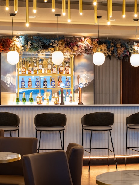 Bar area in Turkish Airlines Lounge by Plaza Premium Group at Edinburgh Airport, featuring seating and drinks display.