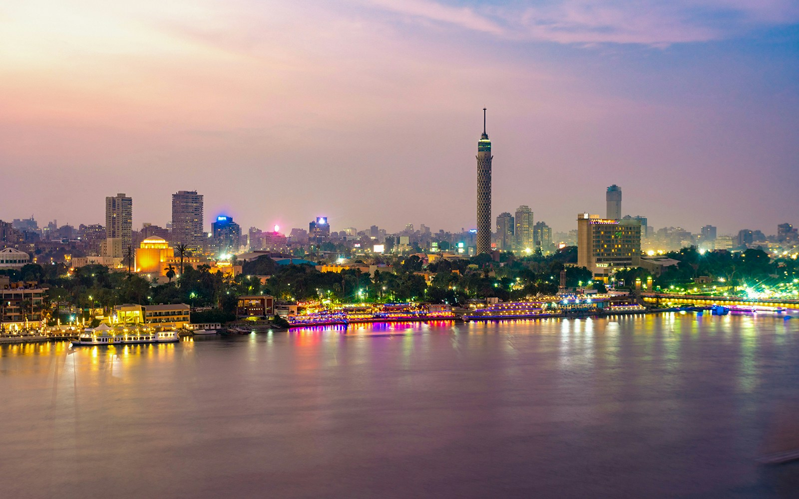 Cairo skyline at dusk with the Nile River and Cairo Tower in view.