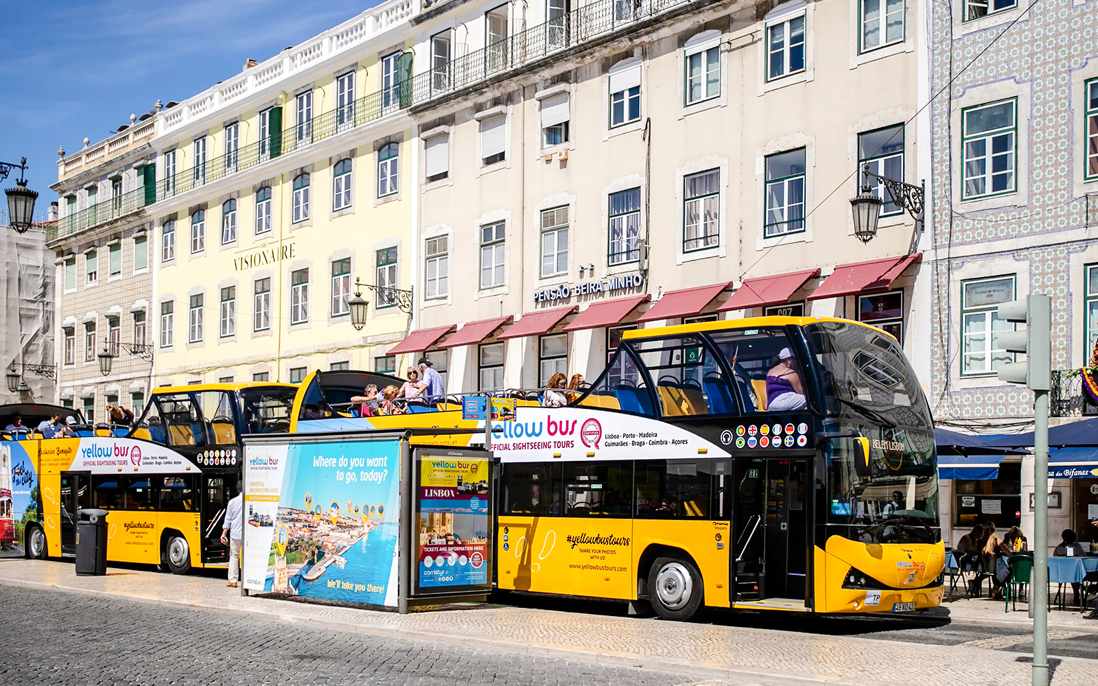 Tourists on a yellow sightseeing bus in Lisbon city center.