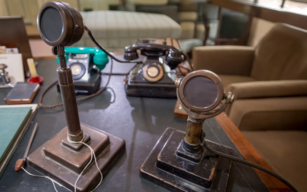 Vintage microphones and telephones on a desk in the Churchill War Rooms, London.