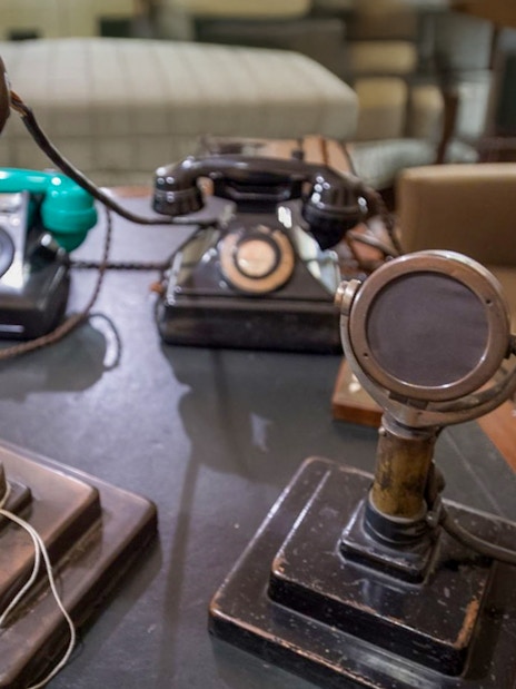 Vintage microphones and telephones on a desk in the Churchill War Rooms, London.