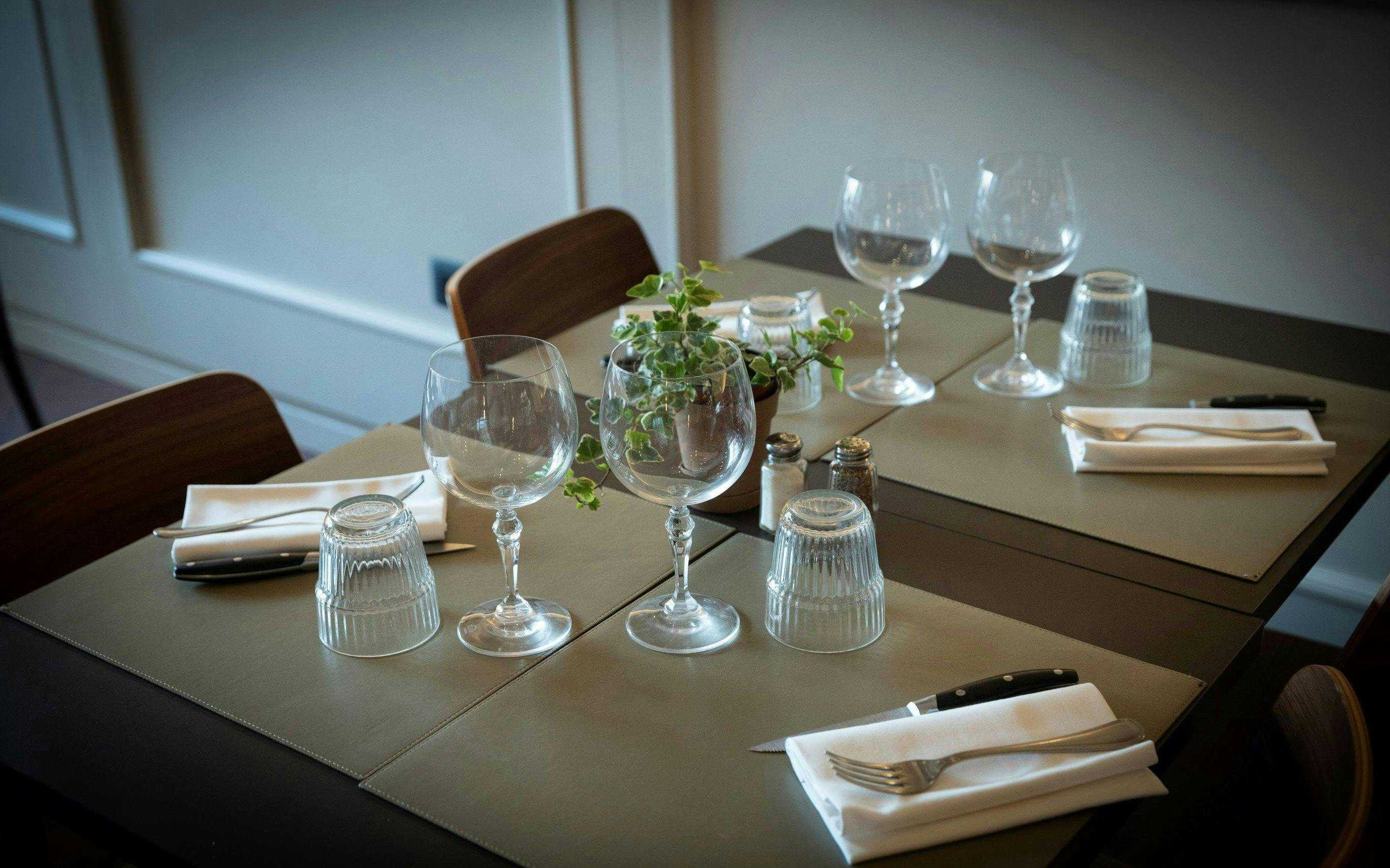 Dinner table set for Tuscan meal in Florence with wine glasses and cutlery.