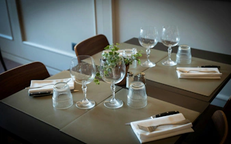 Dinner table set for Tuscan meal in Florence with wine glasses and cutlery.