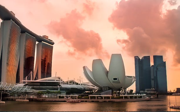 Singapore Marina Bay skyline at sunset with iconic architecture.