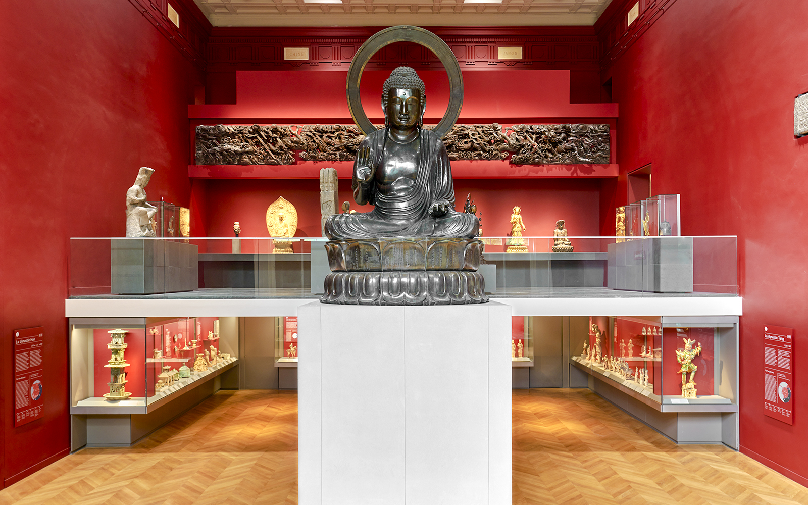 Buddha statue in Cernuschi Museum, Paris, surrounded by Asian art exhibits.