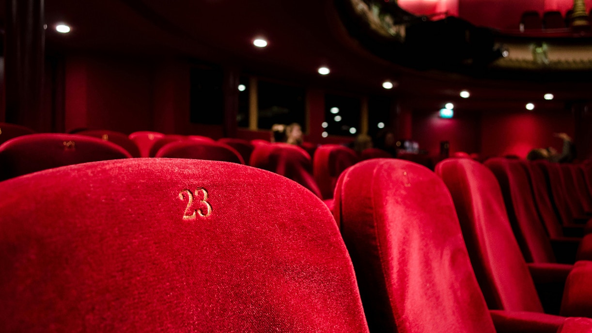 Red velvet seats in a grand opera house theatre.