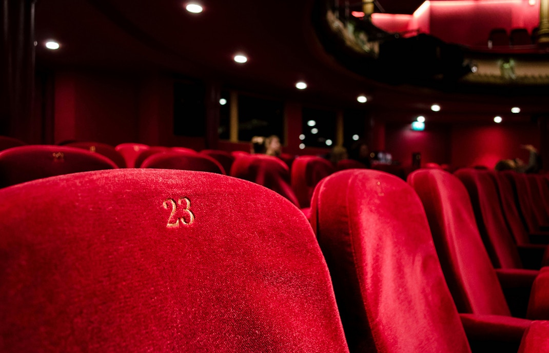 Grand opera house with red coloured seats in a theatre setting.