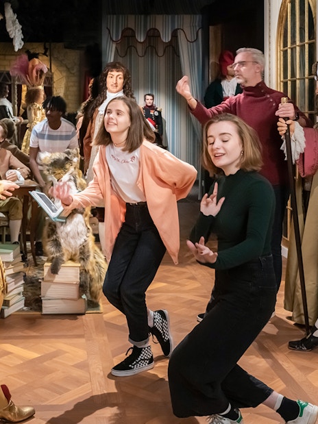 Visitors interacting with wax figures in historical costumes at Grévin Paris Wax Museum.