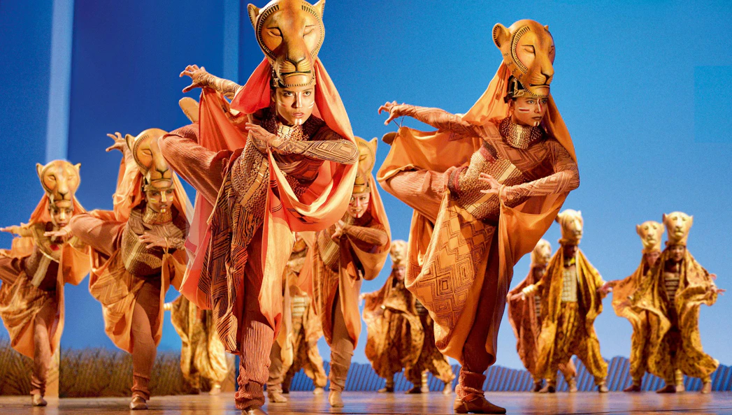 Performers in lion costumes during a Lion King stage show.