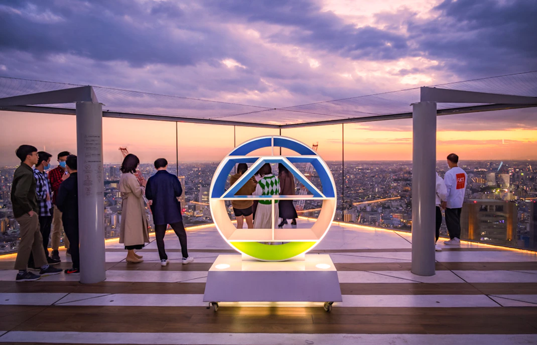 Tourists enjoying sunset views from Shibuya Sky Deck in Tokyo.