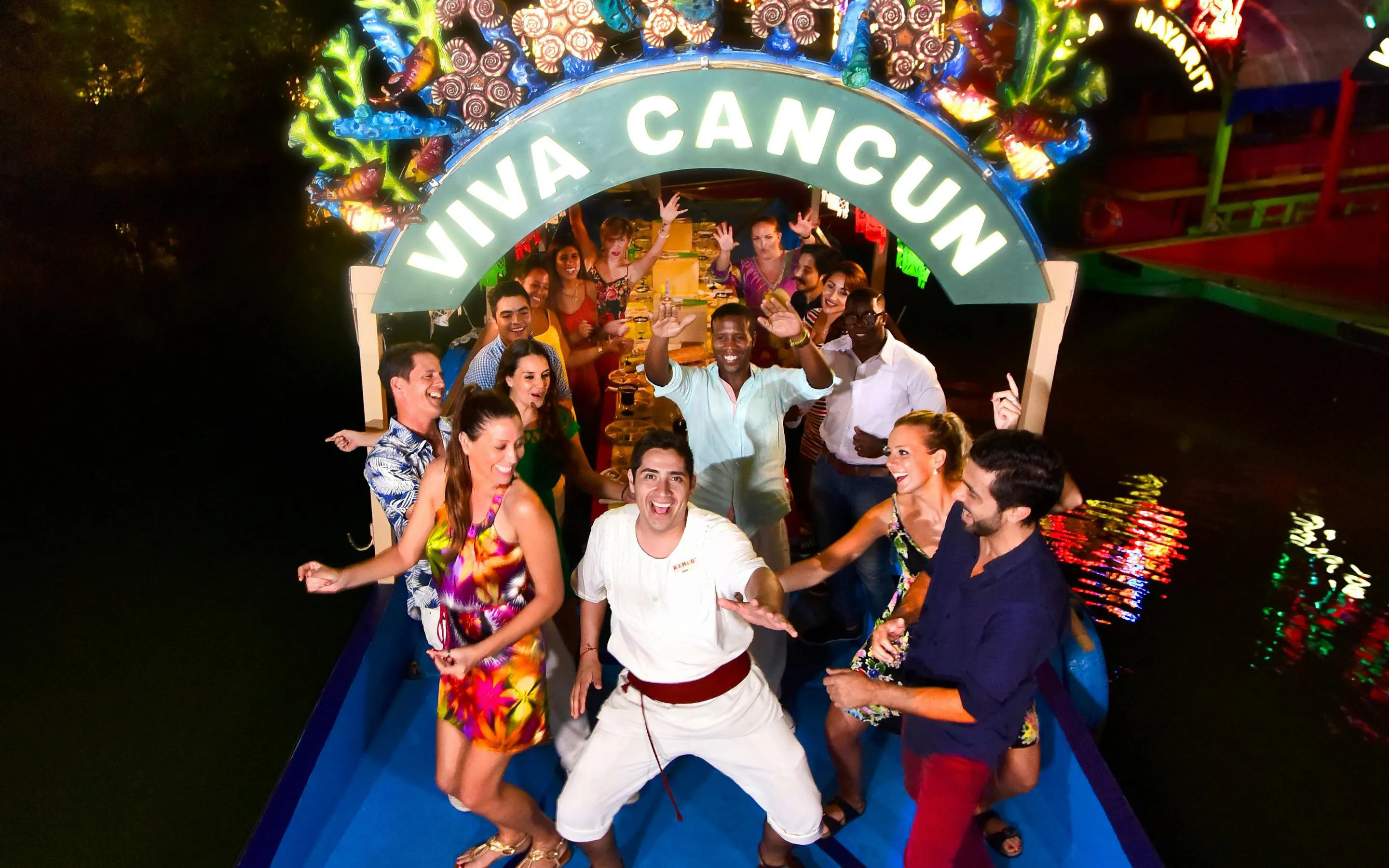 Group enjoying a festive boat ride at Xoximilco Park, Cancun.