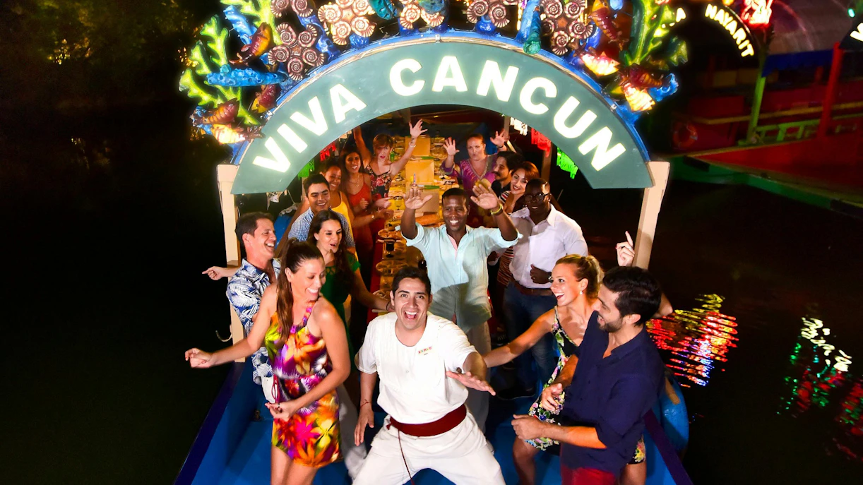 Group enjoying a festive boat ride at Xoximilco Park, Cancun.