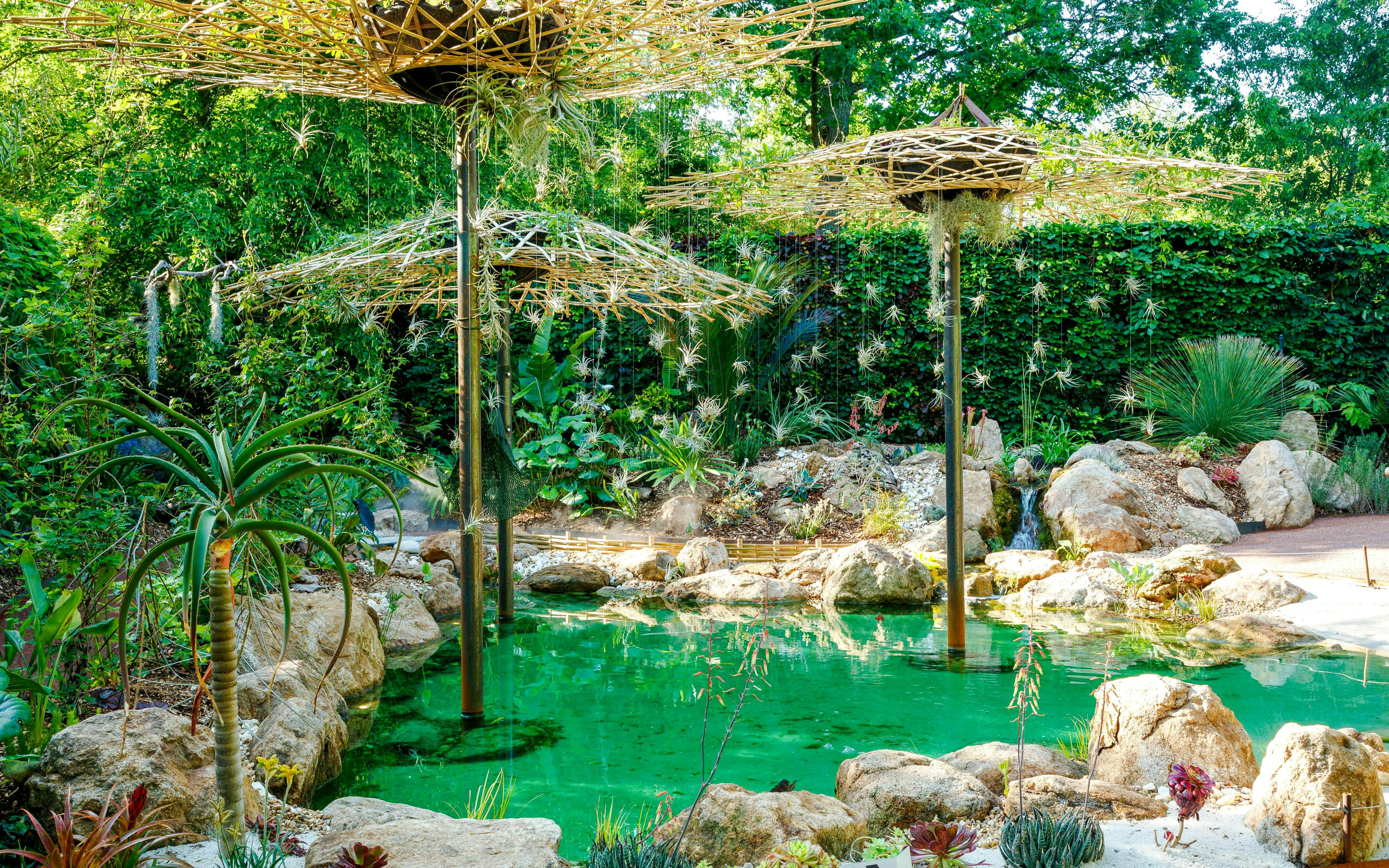 Gardens at Domaine du Chaumont-sur-Loire Castle, Loire Valley, featuring lush greenery and a tranquil pond.
