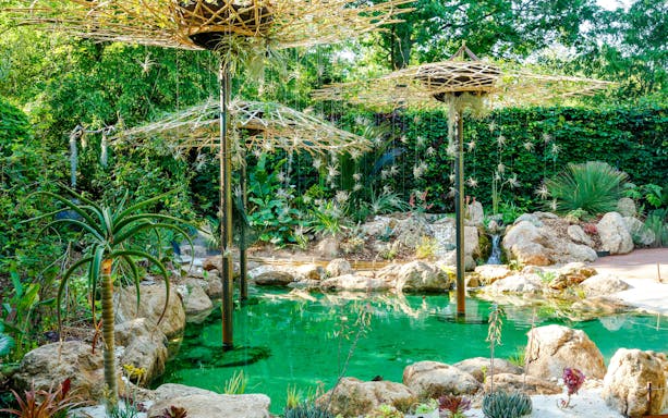 Gardens at Domaine du Chaumont-sur-Loire Castle, Loire Valley, featuring lush greenery and a tranquil pond.
