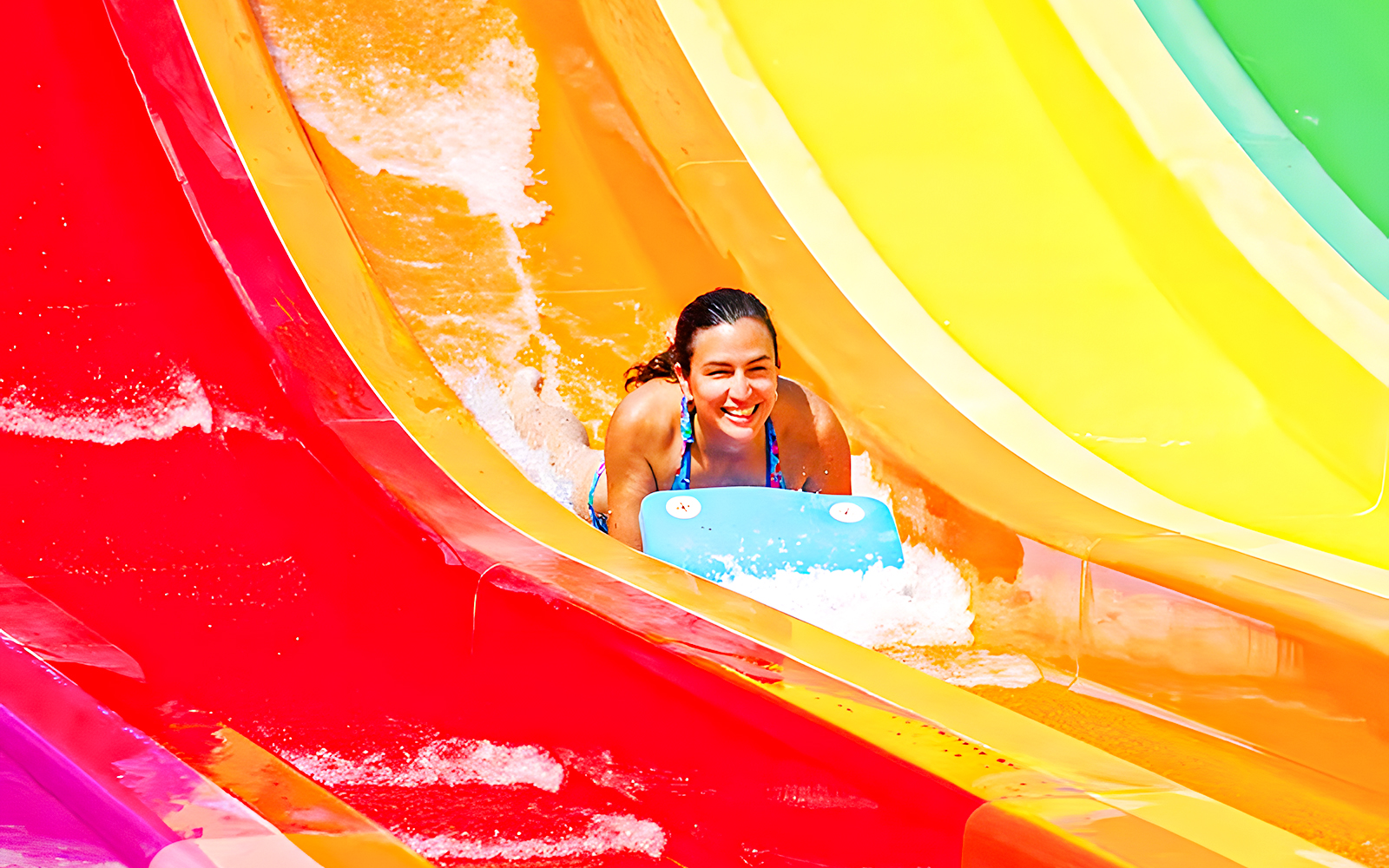 Person sliding down colorful Kangaroa water slide at Aquopolis.