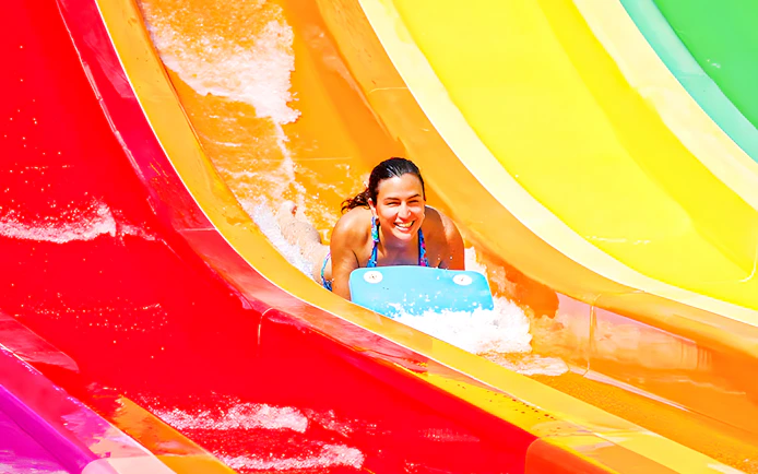 Person sliding down colorful Kangaroa water slide at Aquopolis.