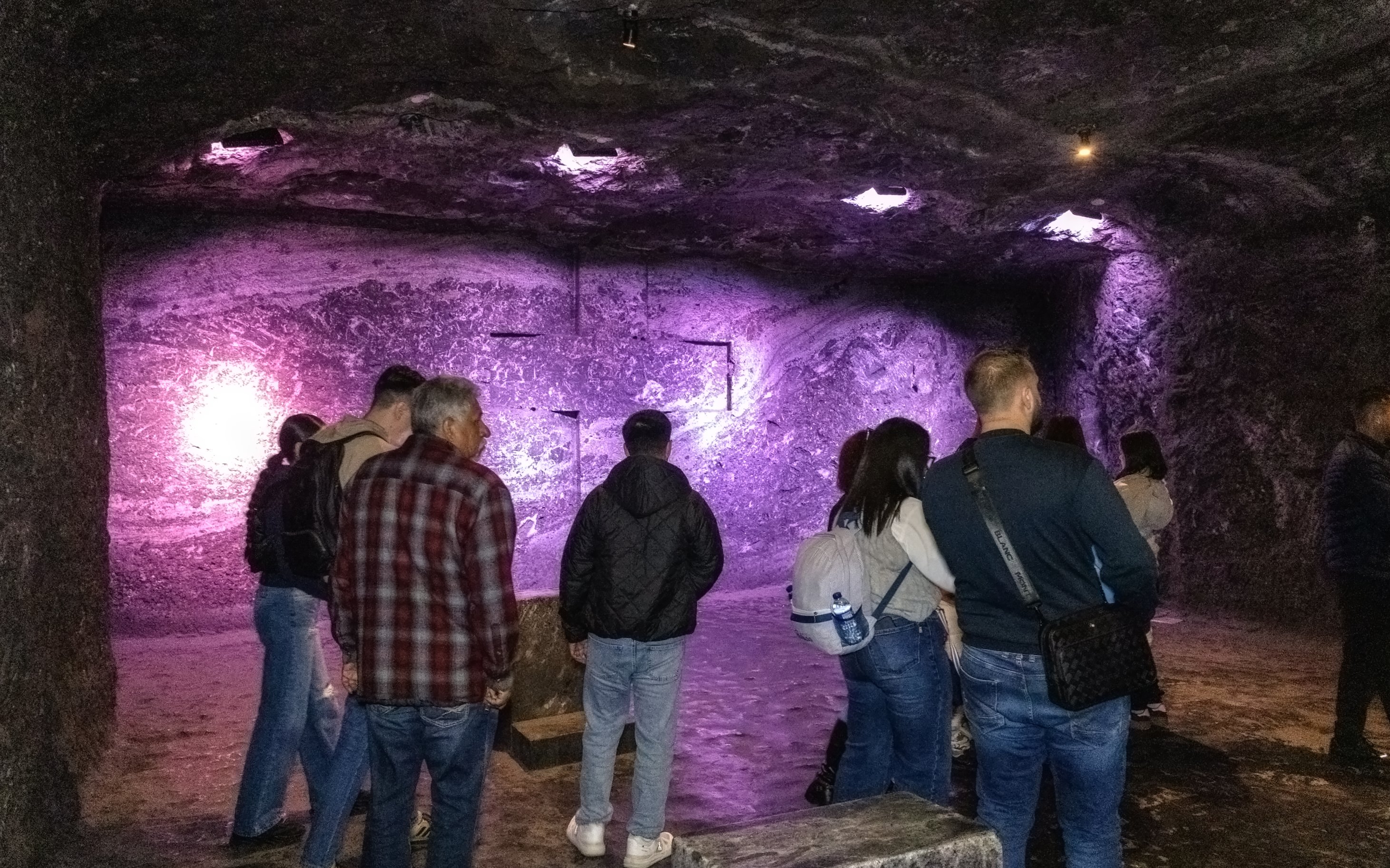 Tourists exploring the illuminated interior of Zipaquira Salt Cathedral, Colombia.