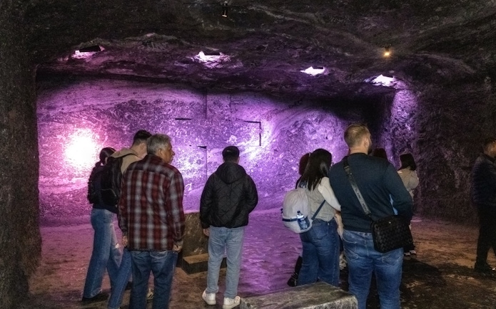 Tourists exploring the illuminated interior of Zipaquira Salt Cathedral, Colombia.