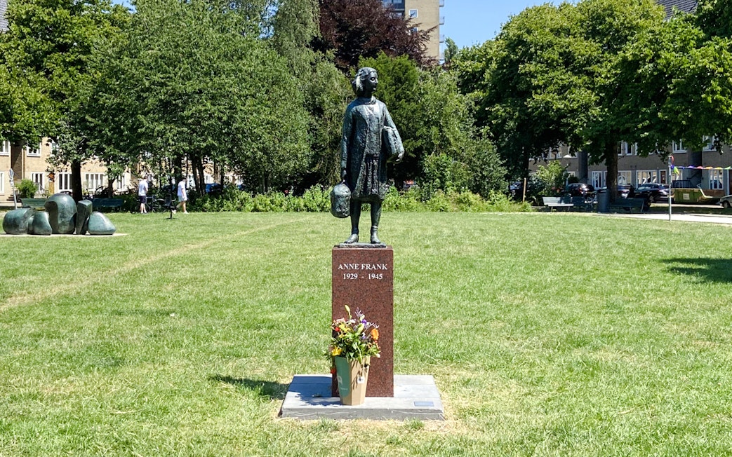 Anne Frank statue in a park setting, Amsterdam.