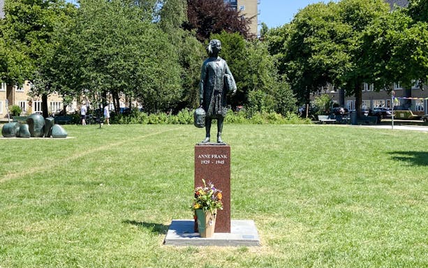 Anne Frank statue in a park setting, Amsterdam.