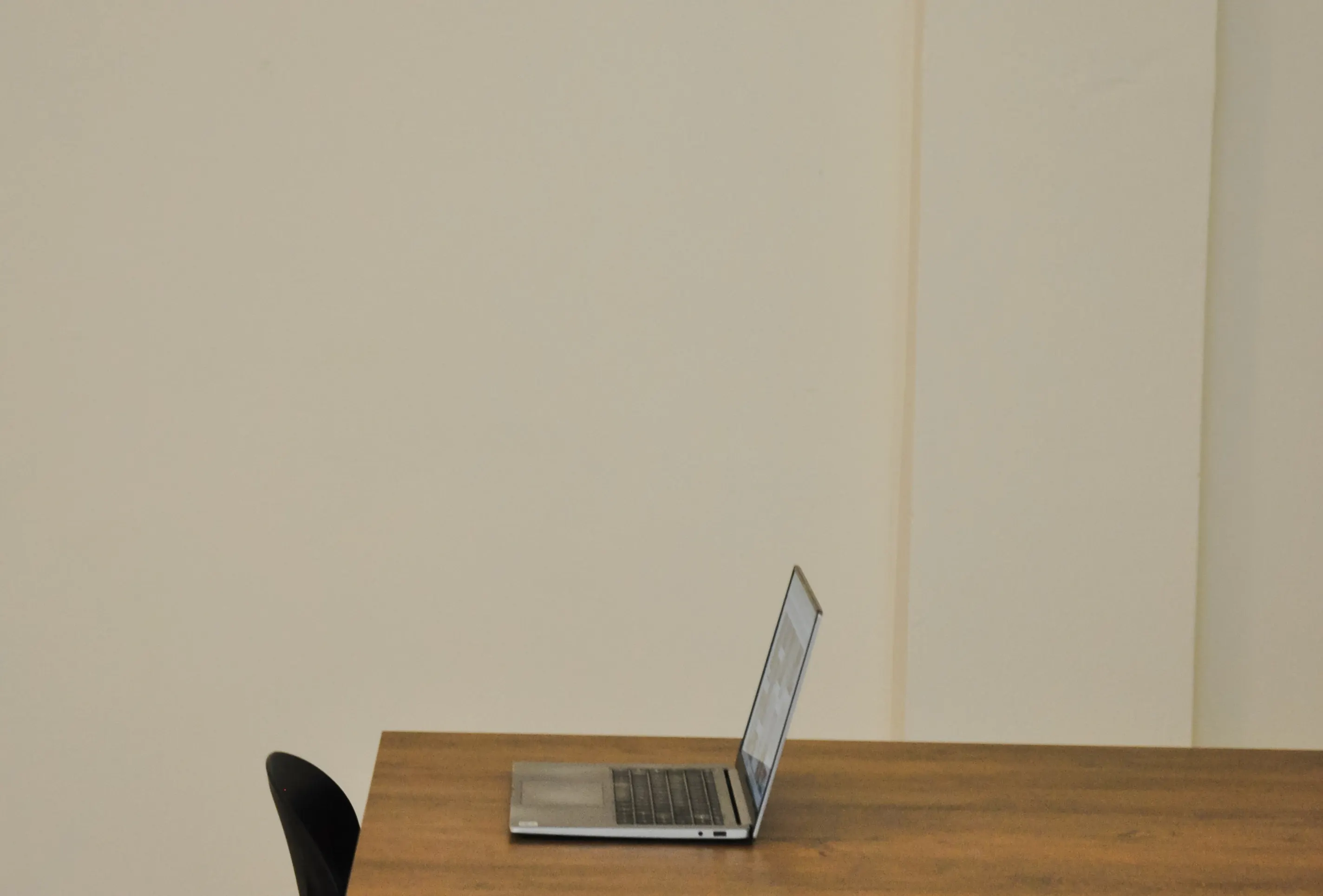 Laptop on a wooden table in an art space, Athens retreat.