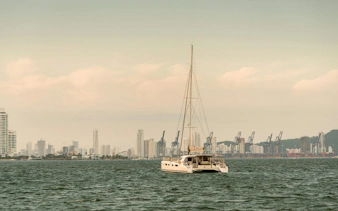Sailboat on Cartagena Bay with city skyline in the background.