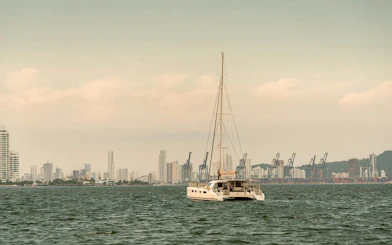 Sailboat on Cartagena Bay with city skyline in the background.