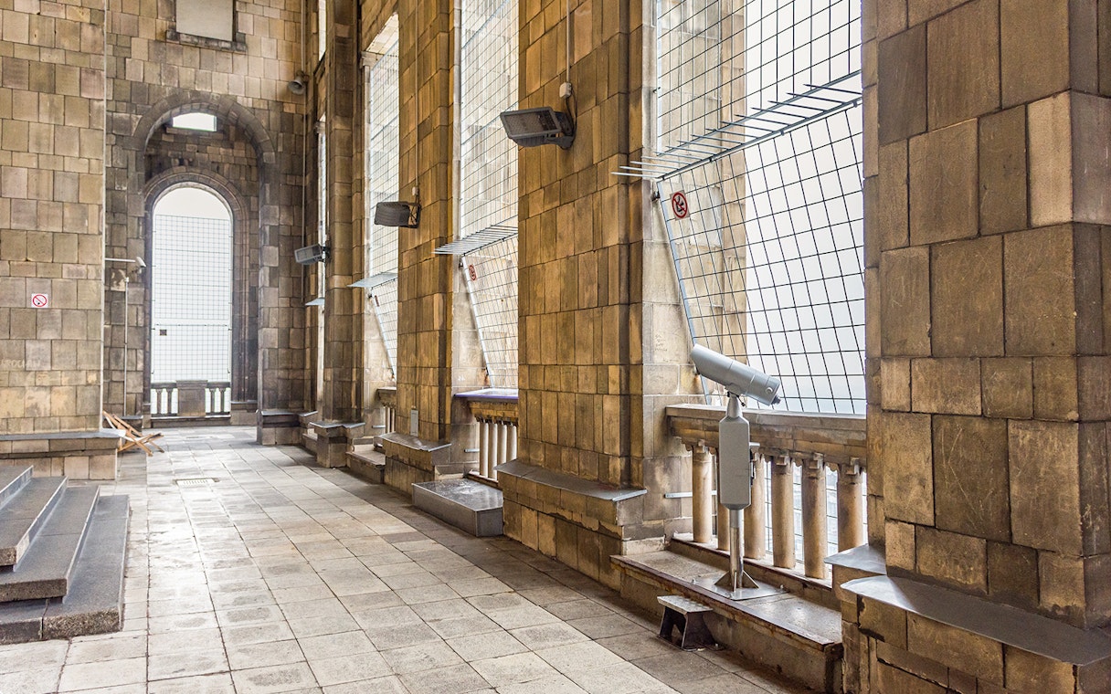 Visitors terrace at Palace of Culture and Science, Warsaw, with viewing telescope and stone columns.