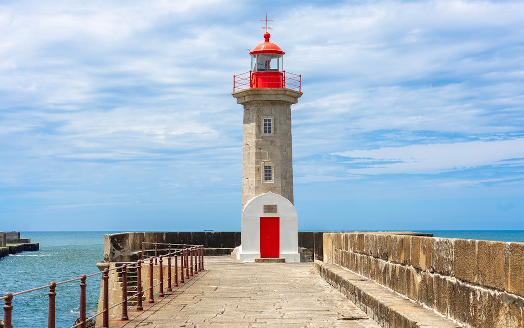 Lighthouse on the pier in Porto, Portugal, with ocean view.