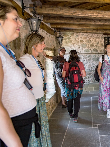 Tour group exploring a historic monastery interior in Meteora, Greece.