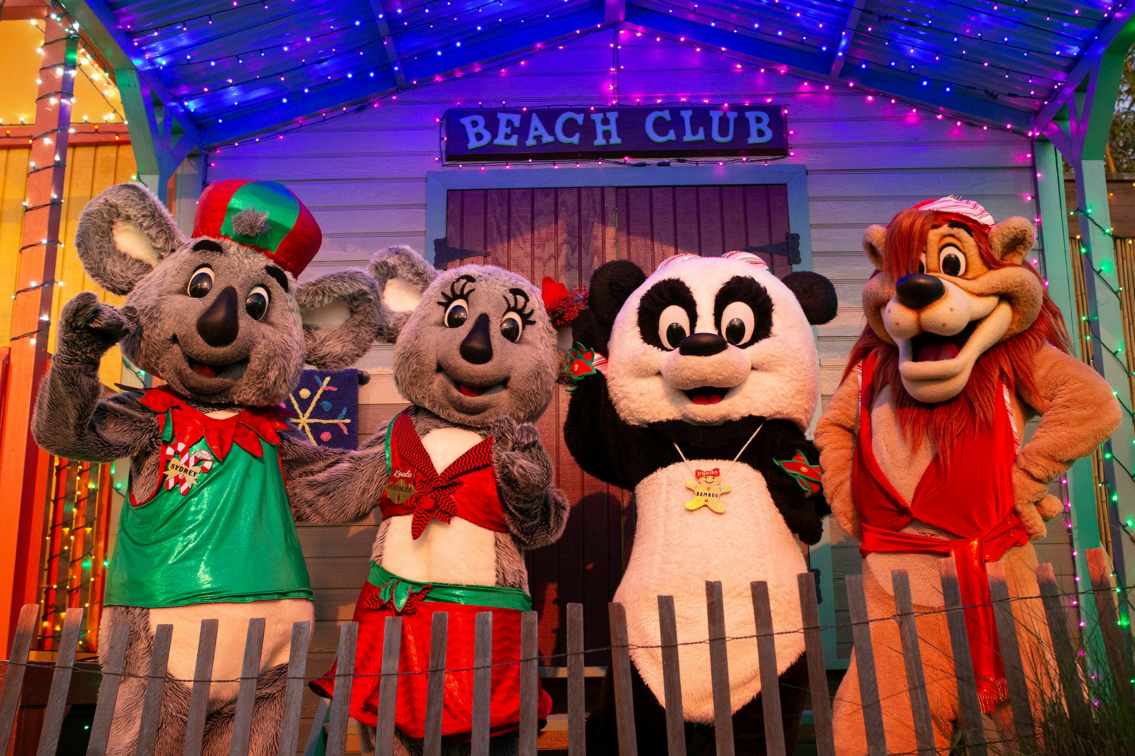 Costumed characters at San Diego Zoo in front of a festive Beach Club backdrop.
